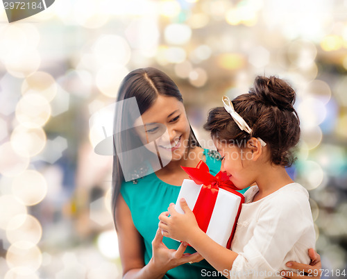 Image of happy mother and little girl with gift box