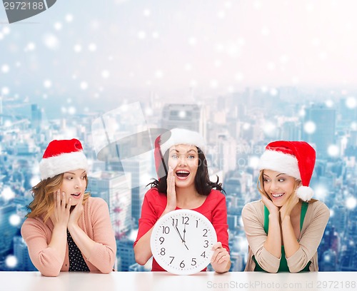 Image of smiling women in santa helper hat with clock