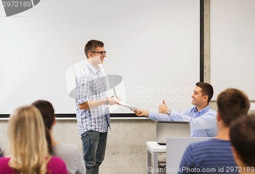 Image of group of students and smiling teacher with notepad