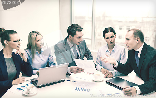 Image of business team with laptop having discussion
