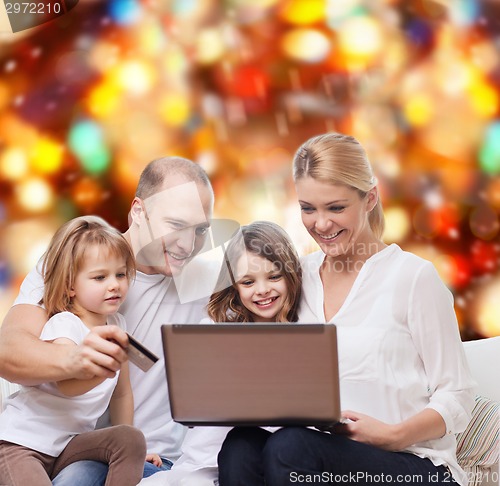 Image of happy family with laptop computer and credit card