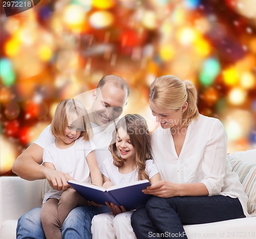 Image of happy family with book at home