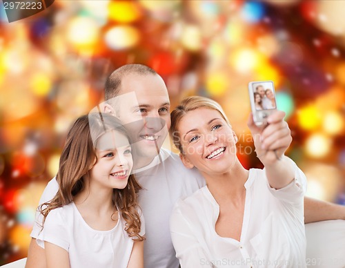 Image of happy family with camera at home