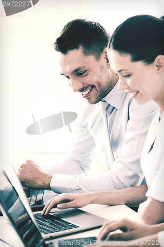 Image of man and woman working with laptop in office