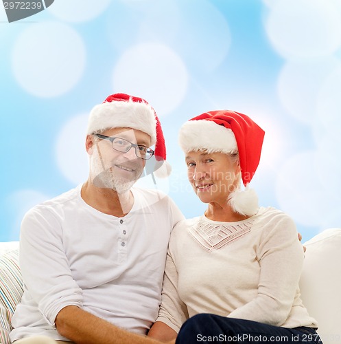 Image of happy senior couple in santa helper hats