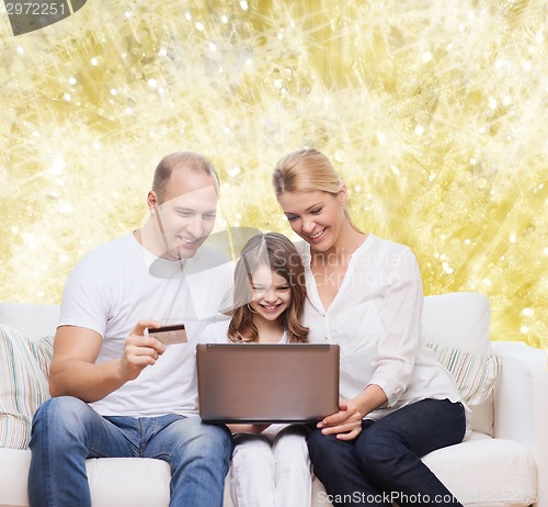 Image of happy family with laptop computer and credit card