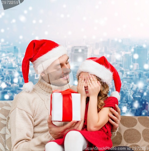 Image of smiling daughter waiting for present from father