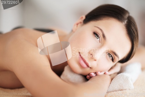 Image of beautiful woman in spa salon with hot stones