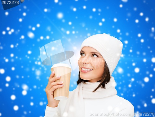 Image of smiling young woman in winter clothes with cup