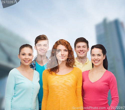 Image of group of smiling teenagers over city background