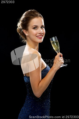 Image of smiling woman holding glass of sparkling wine