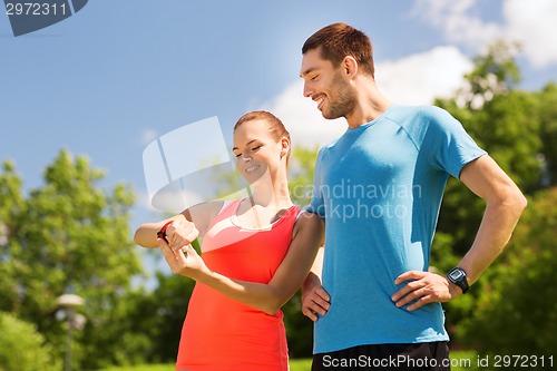 Image of smiling people with heart rate watches outdoors