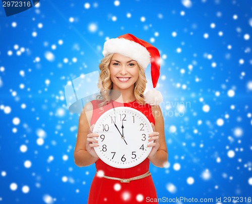 Image of smiling woman in santa helper hat with clock
