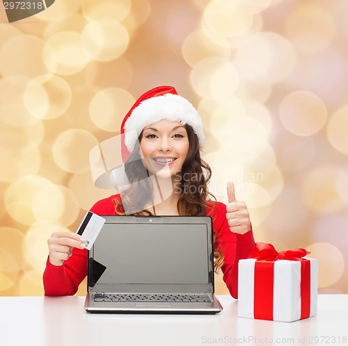 Image of smiling woman with credit card and laptop