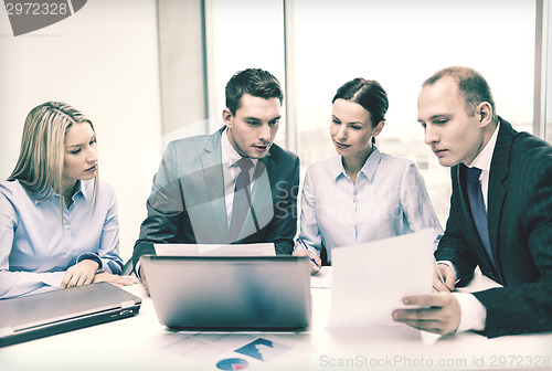 Image of business team with laptop having discussion