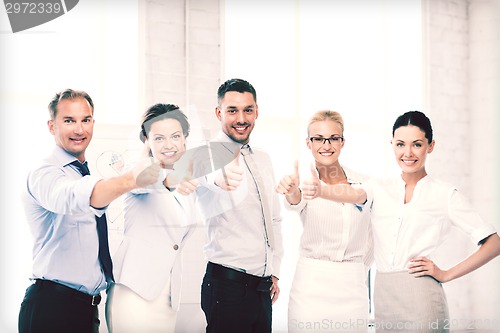 Image of business team showing thumbs up in office