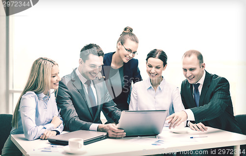 Image of business team with laptop having discussion
