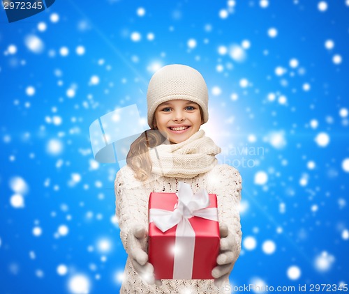 Image of dreaming girl in winter clothes with gift box