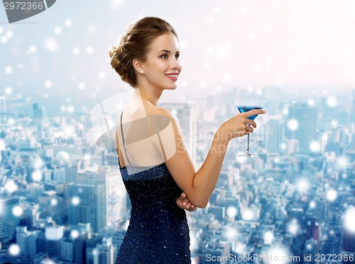 Image of smiling woman in evening dress holding cocktail