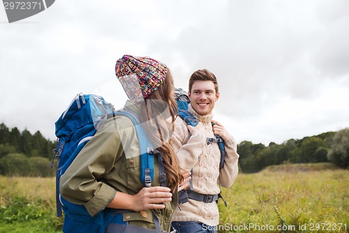 Image of smiling couple with backpacks hiking