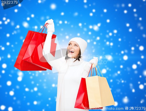 Image of smiling young woman with red shopping bags