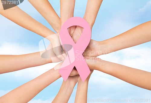 Image of close up of hands with cancer awareness symbol