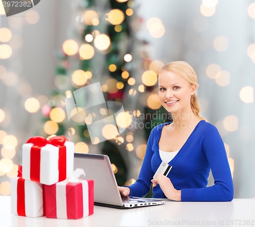 Image of smiling woman with credit card and laptop