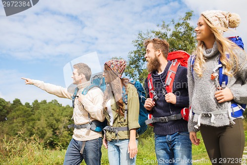 Image of group of smiling friends with backpacks hiking