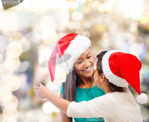 Image of happy mother and girl in santa hats