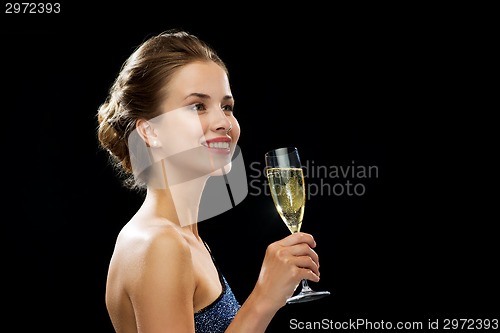 Image of smiling woman holding glass of sparkling wine