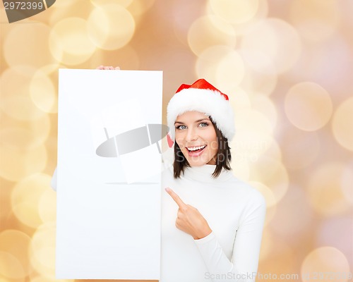 Image of smiling young woman in santa hat with white board