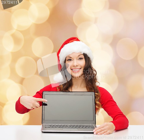 Image of smiling woman in santa helper hat with laptop