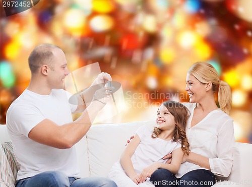 Image of happy family with camera at home