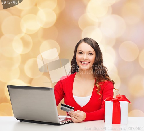 Image of smiling woman with credit card and laptop