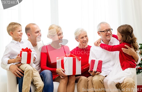 Image of smiling family with gifts at home