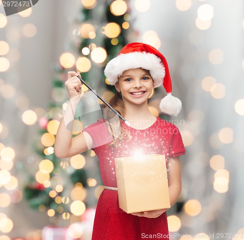 Image of smiling girl in santa helper hat with gift box