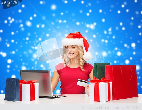 Image of smiling woman with credit card and laptop