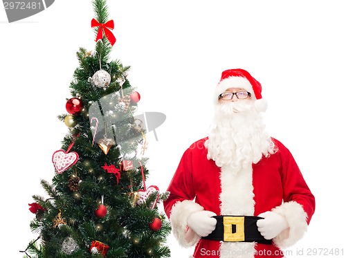 Image of man in costume of santa claus with christmas tree