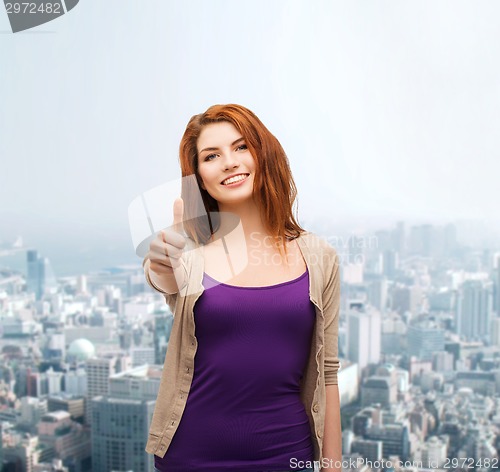 Image of smiling teenage girl showing thumbs up