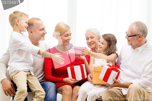 Image of smiling family with gifts at home