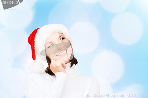 Image of thinking and smiling woman in santa helper hat