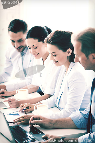 Image of group of people working with laptops in office