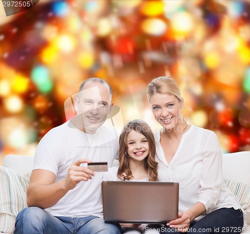 Image of happy family with laptop computer and credit card