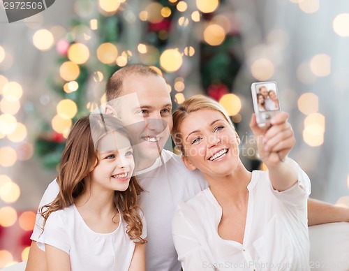 Image of happy family with camera at home