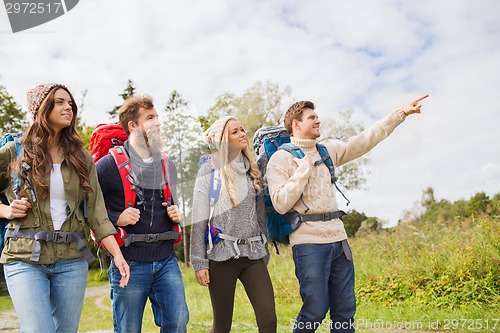 Image of group of smiling friends with backpacks hiking