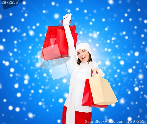 Image of smiling young woman with red shopping bags