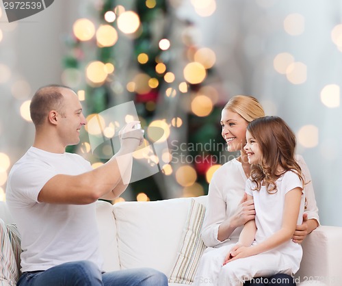 Image of happy family with camera at home