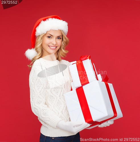 Image of woman in santa helper hat with many gift boxes