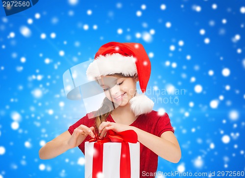 Image of smiling girl in santa helper hat with gift box