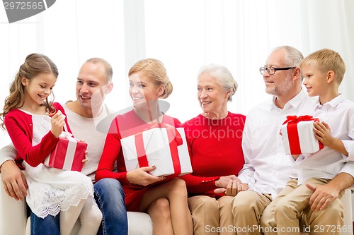 Image of smiling family with gifts at home